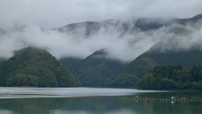 A view of Lake Okutama shrouded in low-hanging clouds and fog
