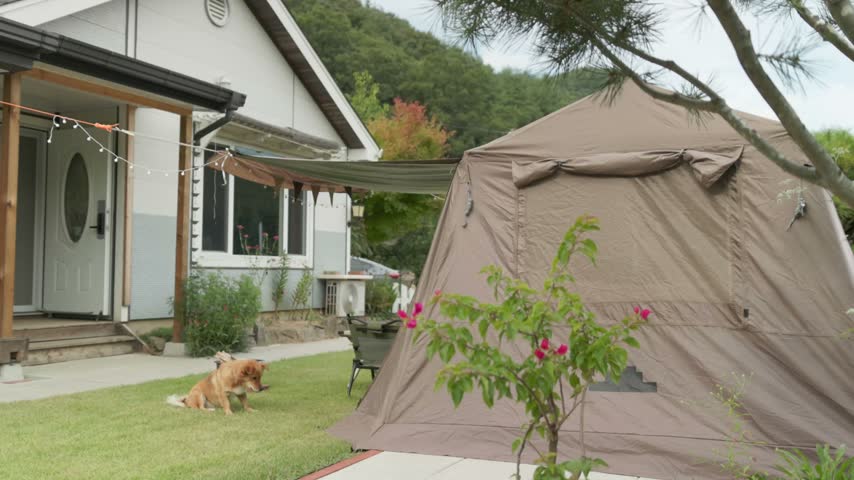 A camera slide shows a camping tent set up in a home backyard with the house in the background.