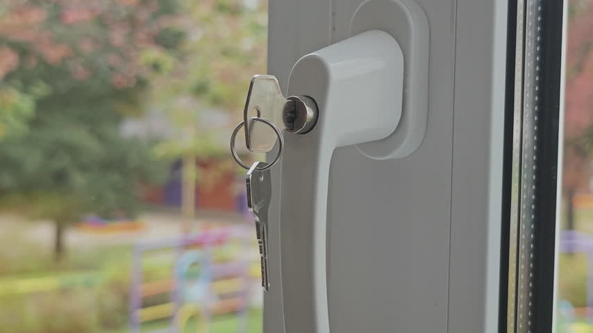 Child safety lock with a key on a plastic window handle preventing accidental opening for security