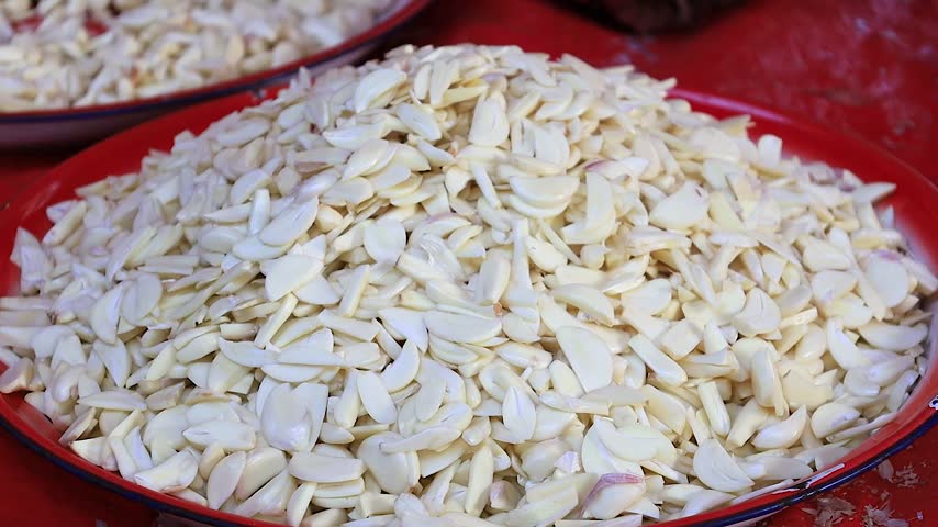 Fresh Sliced Garlic Cloves Piled on a Tray Ready for Cooking.