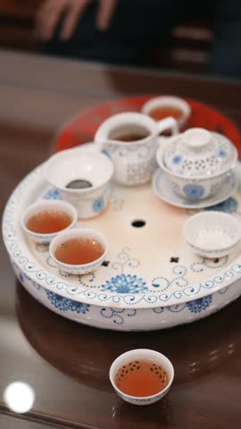 Traditional Chinese Gongfu Tea Set with Blue-and-White Porcelain on Rotating Tray, Featuring Oolong Tea in Small Cups and Ceramic Pot, Cultural Tea Ceremony Setup