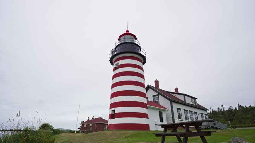 West Quoddy Head Light with iconic red and white stripes standing on the grounds of Quoddy Head State Park in Lubec, Maine.