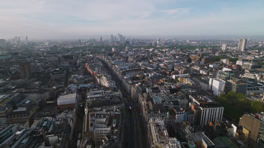 Bright daylight across Oxford Circus, Superb Quality, aerial view shot of Central London, England, United Kingdom showing the famous junction of Oxford Street and Regent Street with surrounding West End buildings and busy city streets, crystal clear crisp image