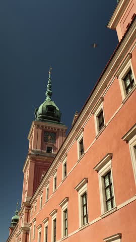 Vertical architectural view of a historic Warsaw building featuring an ornate facade detailed windows decorative elements and timeless European style in the heart of the Polish capital