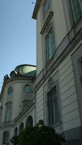 Vertical close view of historic architecture in Warsaw showing an ornate building facade with decorative details tall windows and classic European design representing Polish urban heritage