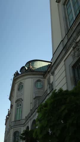 Vertical view of a historic building facade in Warsaw featuring ornate architectural details decorative windows elegant columns and classic European design reflecting the cultural heritage of Poland