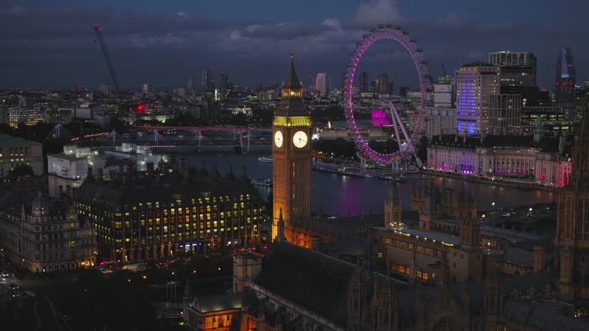 Evening city glow across Westminster, Superb Quality, aerial view shot of London, England, United Kingdom showing the Palace of Westminster and surrounding skyline illuminated at night with glowing landmarks, lit streets and crisp architectural detail, crystal clear crisp image