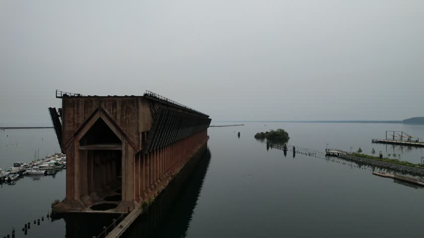 Slow rise over lake Aerial of Marquette Michigan on an overcast summer day in the Upper Peninsula. Drone Passes by old Ore dock in the harbor.