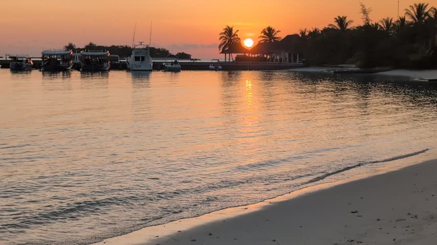 Vibrant orange sunset over a calm body of water