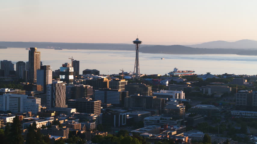 Bright sunshine across downtown Seattle, Superb Quality, aerial view shot of Seattle, Washington, USA showing the downtown skyline, modern skyscrapers and dense urban architecture under clear sunny daylight, with crisp city detail and a vibrant summer atmosphere, crystal clear crisp image