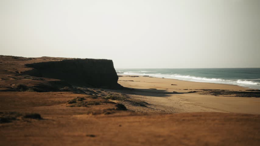 Desert Cliffs Overlooking Sandy Beach and Ocean Waves