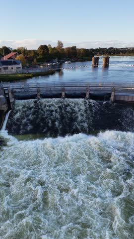 Aerial view of Salmon Weir with powerful water flow on the River Corrib beside historic stone structures in Galway City Ireland.