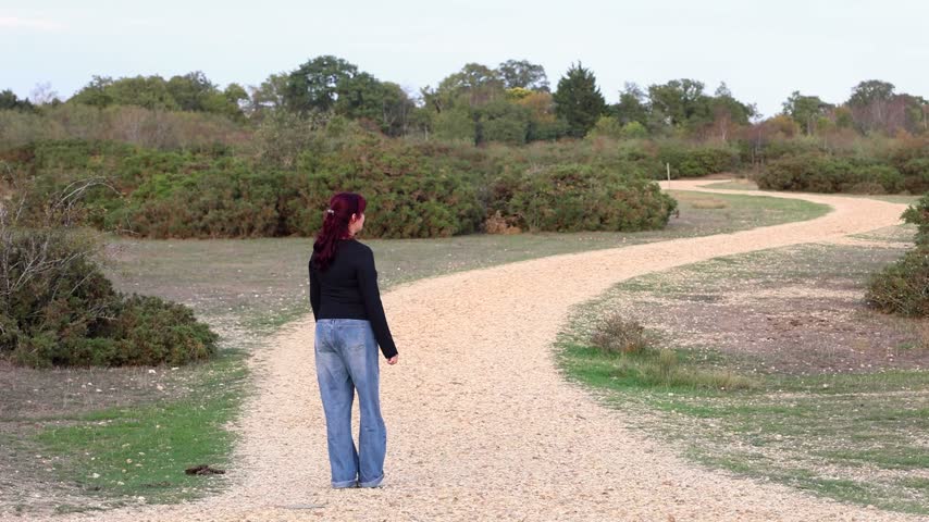Woman Walking Alone Through Dry Desert Landscape