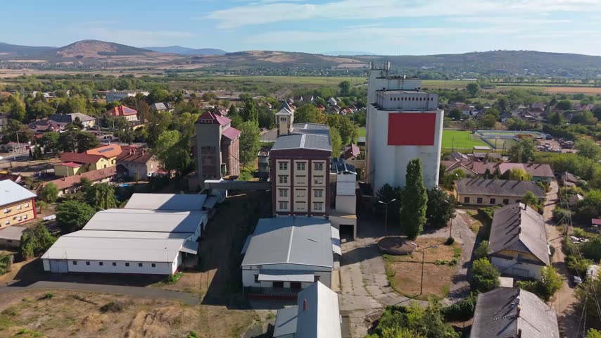 Selypi Malom in Lőrinci, Heves County, Hungary, abandoned industrial mill and grain silo complex in a rural townscape, historic food production site seen by drone.