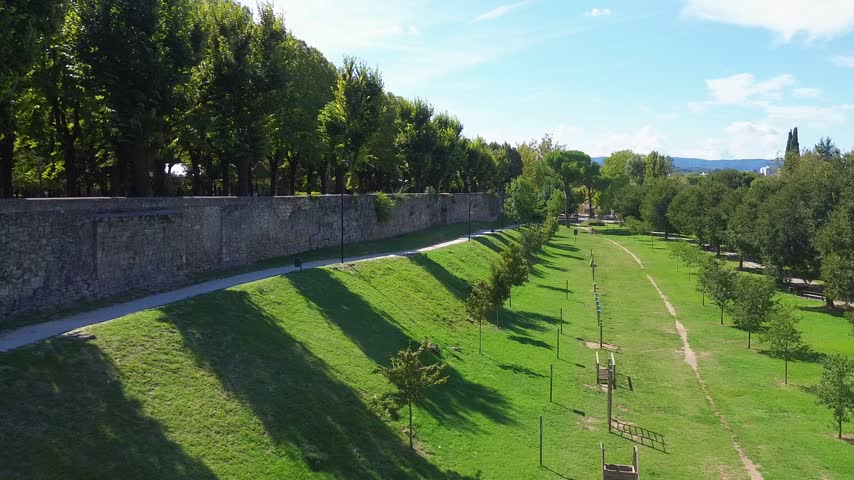 Scenic drone view of Passeggiata Park in Terni, Umbria, Italy, with lush trees and green parkland creating a peaceful natural setting on a tranquil morning.