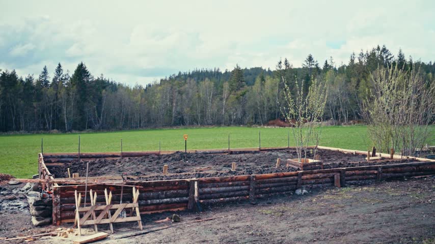Man Is Working On DIY Huge Rustic Raised Garden Bed Enclosed By A Stacked Timber Log. Timelapse