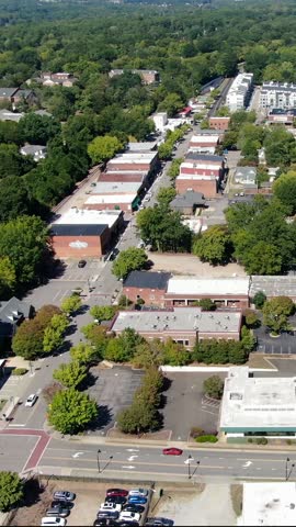 Aerial vertical view of historic downtown main street buildings, parking lots, and tree-lined streets in Wake Forest, North Carolina.