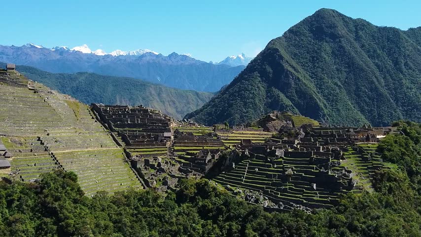 Stunning panoramic view of the machu picchu inca citadel in peru. The famous ruins surrounded by green mountains and snow capped peaks