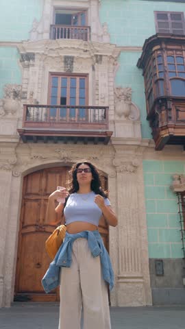 Young smiling woman strolling through the historic center of lima, peru. Slow motion low angle shot of a tourist enjoying her trip