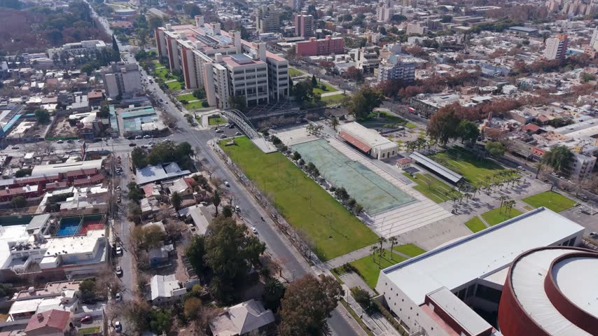 Plaza del Bicentenario spreads between government buildings and Teatro del Bi centenario in San Juan, with landscaped lawn, palm trees and civic plaza design, drone descent push in.
