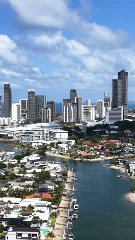 High angle aerial view over waterfront houses, canals, and Surfers Paradise skyscrapers in Gold Coast.