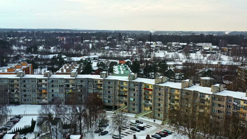 Elevated perspective of a city district with Soviet-era apartment blocks during a winter snowfall