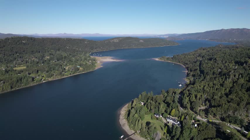 4K drone aerial view of Lake Nahuel Huapi from Cerro Campanario in Bariloche, Río Negro, Argentina. Deep blue waters stretch across the Patagonian landscape surrounded by forested mountains.