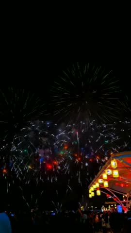 Vibrant fireworks display illuminating the dark night sky over a festive outdoor event celebration