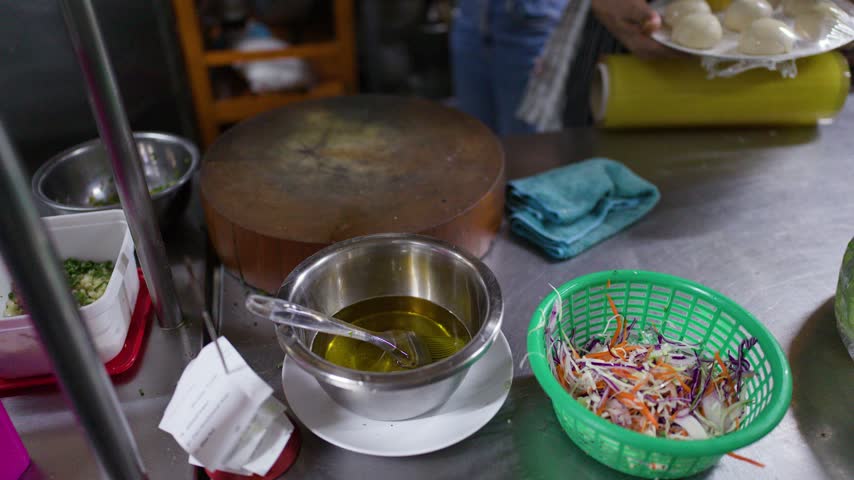 High-angle view of a stainless steel kitchen counter prepared with ingredients and cooking oil.