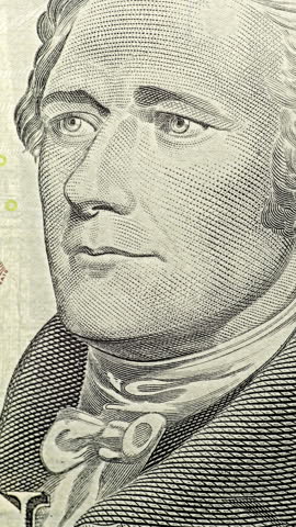 Alexander Hamilton portrait under green scan. Portrait on ten dollar bill glows as green security scan moves across banknote.