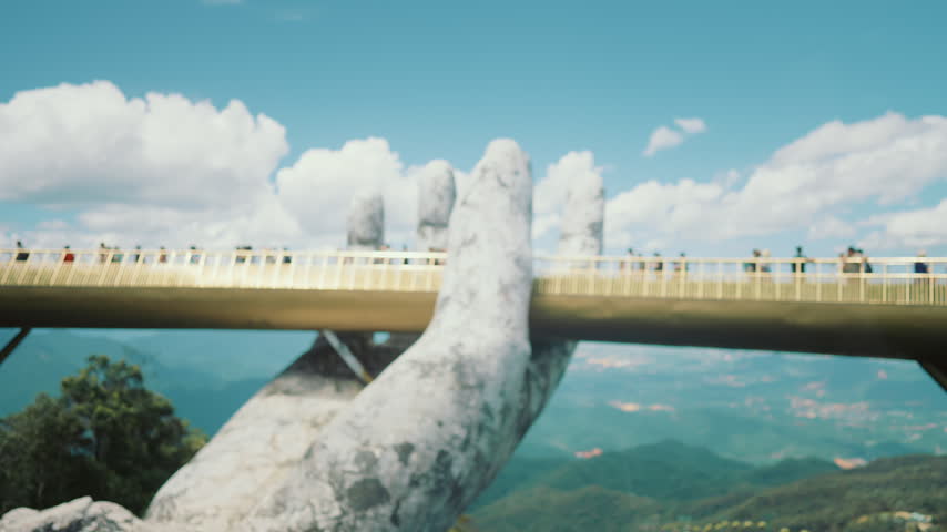 Unique architecture of modern Golden Bridge in Vietnam, people walking in months . Summer vacation and tourist trip to Asia, explore asian region, tourist attraction and location for observe mountains