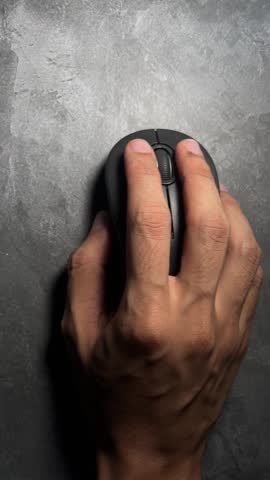 person hand holding computer mouse on dark surface