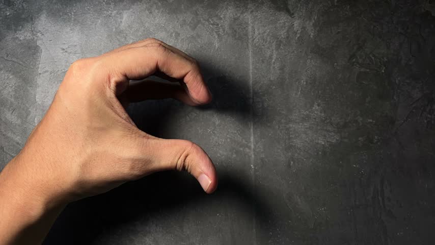 two hands forming heart shape on dark background