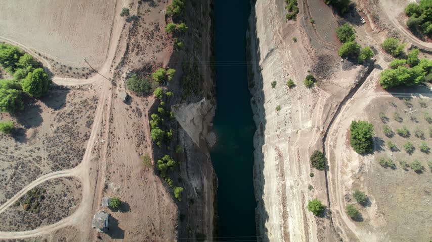 Aerial view of the Isthmus of Corinth with its steep rocky walls and narrow canal cutting through the landscape in Corinth, Greece.