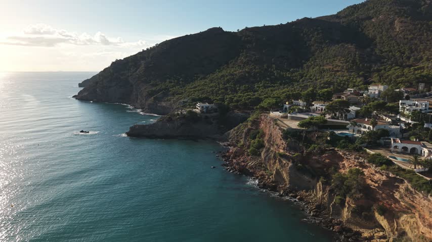 People explore the beautiful coastline of the Costa Blanca, specifically in Albir and Altea, Spain. The sun shines on the Mediterranean Sea and the landscape.
