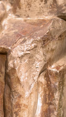 Camera tilts down ancient Egyptian stone pharaoh sculpture inside the Egyptian Museum in Turin, Italy.