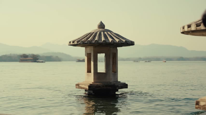 Historic stone pavilion standing in the waters of West Lake, Hangzhou