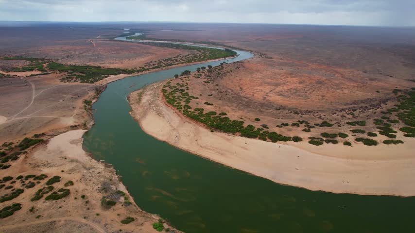 Aerial view of the meandering Galana River flowing through the arid landscape of Tsavo East, Tana River County, Kenya.