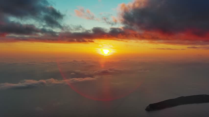 Aerial view of a vibrant sunset over the Adriatic Sea with a coastal peninsula visible in Montenegro.