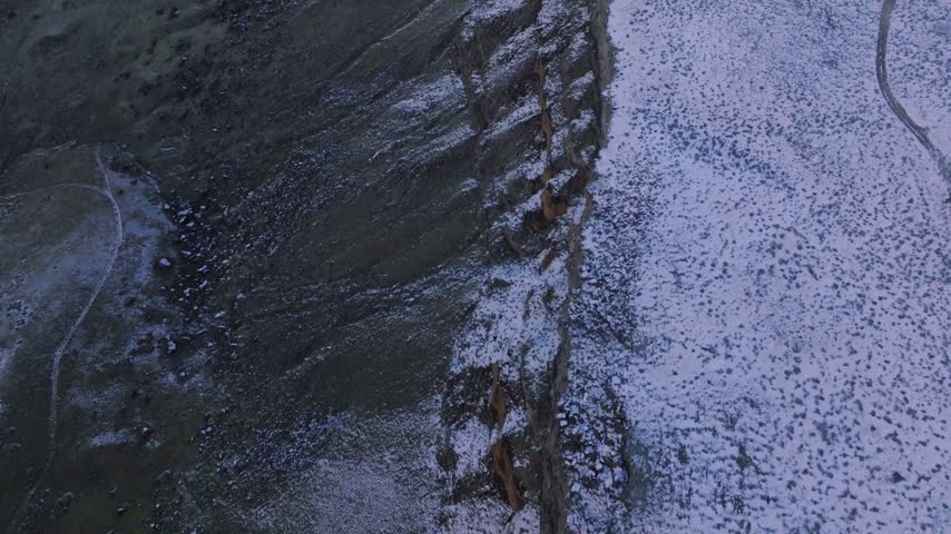 Canyon carved deeply into snowy terrain captured from an overhead aerial perspective during cold winter conditions
