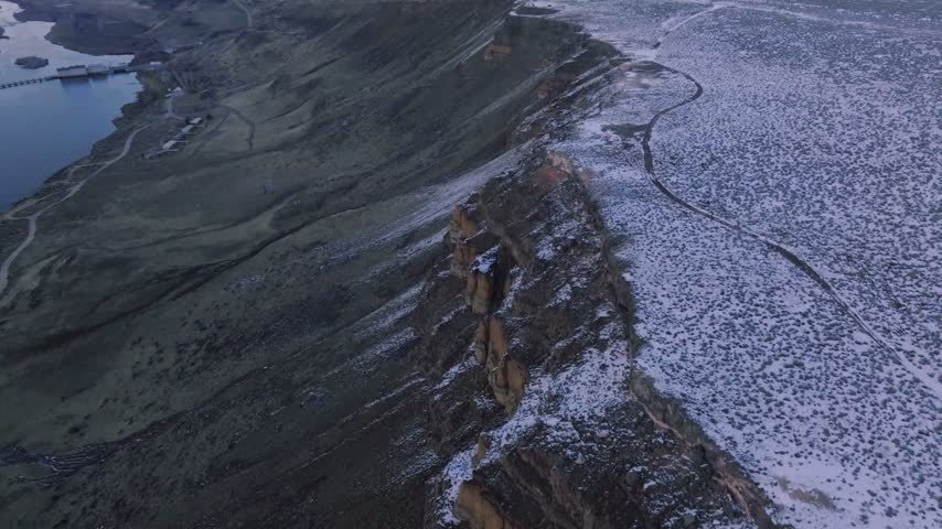 Canyon landscape aerial view reveals rugged rocky cliffs and a snow dusted plateau in winter wilderness