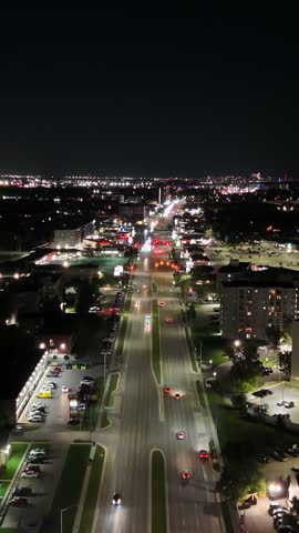 High altitude vertical night drone aerial flying forward over Pembina Highway showing city lights and urban traffic in Winnipeg, Manitoba, Canada.
