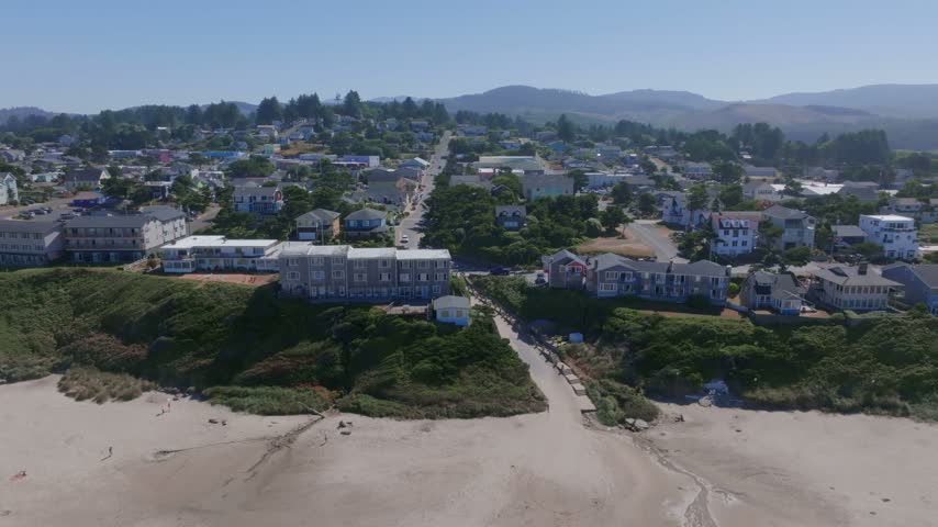 Oregon coastal community viewed from above showing clifftop buildings residential streets and sandy shorelines during daylight