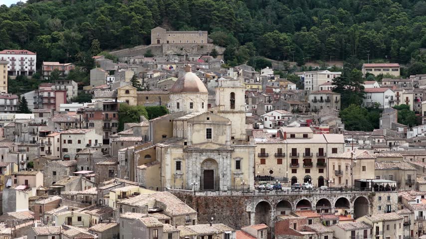 Aerial drone view of Petralia Sottana in Sicily, Italy, showing historic sicilian town buildings, churches, rooftops and traditional architecture surrounded by the Madonie mountain landscape. Sicilian hill town.