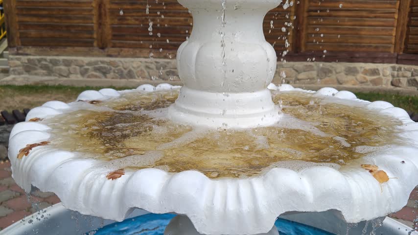 An antique decorative water fountain in a park.