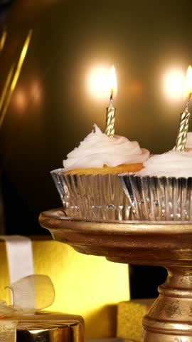 Cupcakes with Candles on a Gold Tray Rotating in a Party Setting