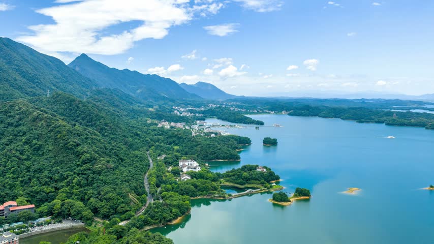 Aerial view of lush green mountains surrounding a vast lake reservoir landscape