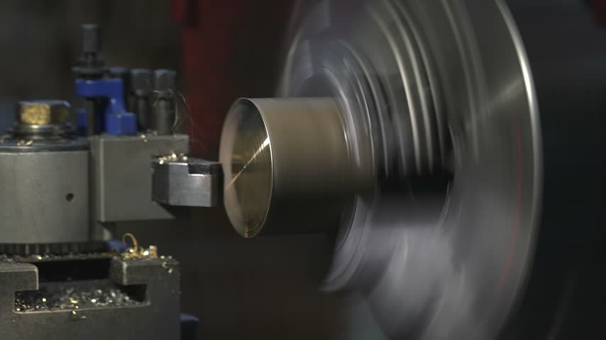 the process of manufacturing a metal part from a brass blank on a CNC lathe using drills and cutting tools