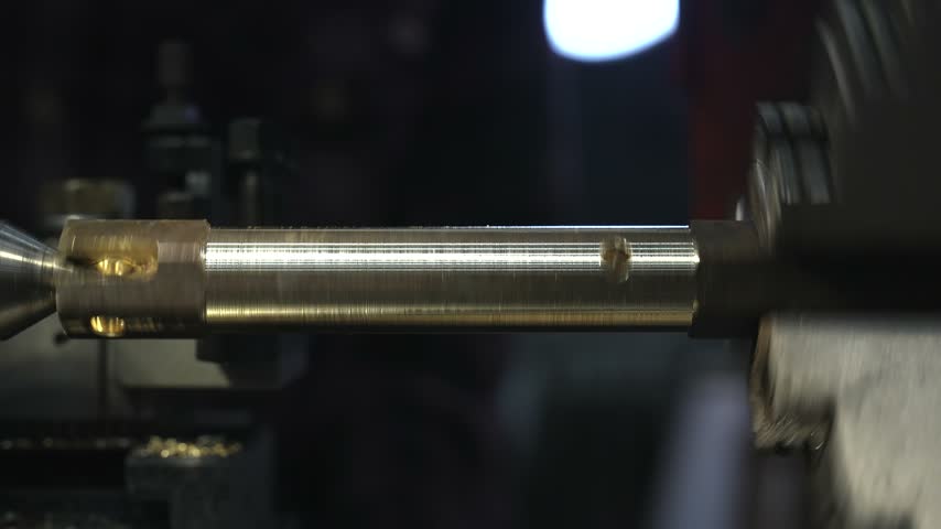 the process of manufacturing a metal part from a brass blank on a CNC lathe using drills and cutting tools