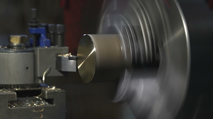 the process of manufacturing a metal part from a brass blank on a CNC lathe using drills and cutting tools